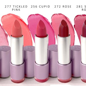 Puede incluir: Cinco tubos de lápiz labial con diferentes tonos de rosa y rojo. Los tonos de lápiz labial están etiquetados como "277 Sugar Rose", "277 Tickled Pink", "256 Cupid", "272 Rose" y "281 Sandy Rose".