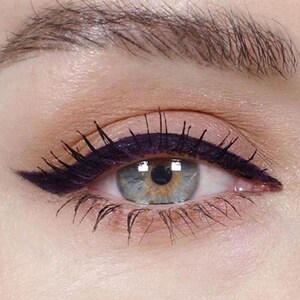 Peut inclure: Gros plan sur l'&oelig;il d'une femme avec un eye-liner noir &eacute;pais en forme d'aile. L'eye-liner est appliqu&eacute; avec pr&eacute;cision et s'&eacute;tend au-del&agrave; du coin externe de l'&oelig;il.