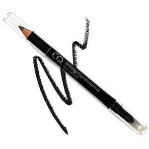 Puede incluir: Lápiz delineador de ojos negro con tapa transparente y el texto "liningimpressions CQ eye pencil" impreso en el lateral.