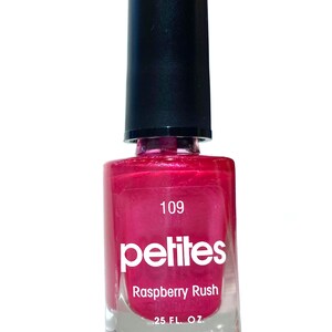 Puede incluir: Una botella de esmalte de u&ntilde;as rosa con una tapa negra. La botella est&aacute; etiquetada con "petites" y "Raspberry Rush" con el n&uacute;mero 109. La botella contiene 0,25 onzas l&iacute;quidas de esmalte de u&ntilde;as.