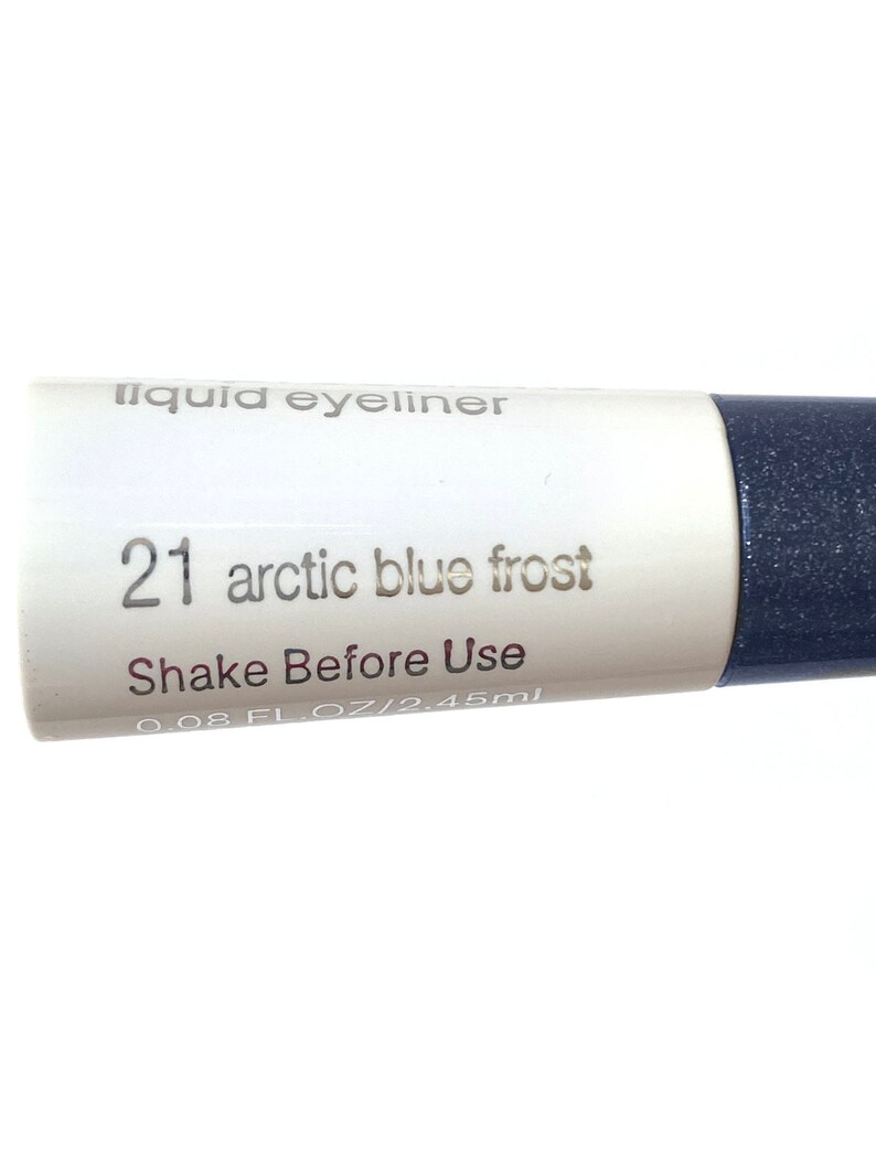 Peut inclure: Un tube blanc de liner liquide avec le texte "liquid eyeliner" et "21 arctic blue frost" imprim&eacute; dessus. Le tube indique &eacute;galement "Shake Before Use" et "0.08 FL. OZ/2.45ml".