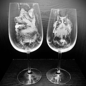 Peut inclure: Deux verres à vin en verre transparent avec des images gravées d'un chien et d'un chat. Le chien est un berger allemand à poil noir et brun. Le chat est un chat noir et blanc à poils longs.