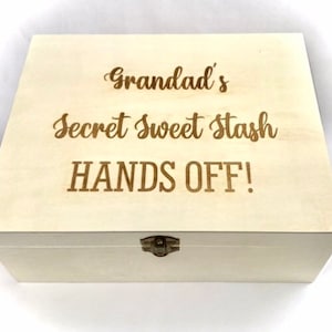 Op de afbeelding: Een witte houten doos met een scharnierend deksel en een messing sluiting. De doos is gegraveerd met de tekst "Grandad's Secret Sweet Stash HANDS OFF!"