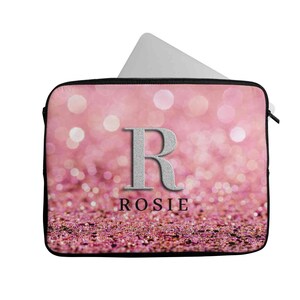 May include: Pink glitter laptop sleeve with a silver letter R and the name Rosie printed in black.
