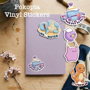 Può includere: Una collezione di adesivi in vinile colorati con personaggi dei cartoni animati. Un adesivo mostra una tartaruga blu con il testo "WA... WATER". Altri adesivi includono una creatura blu con il testo "I'VE RUN OUT OF PP" e una creatura arancione con il testo "I... I FREW UP."