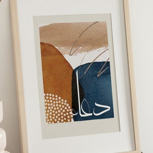May include: A framed abstract art print with a beige background, featuring a blue, brown, and black geometric design with white polka dots and the Arabic word "حلم" (meaning "dream") in white.