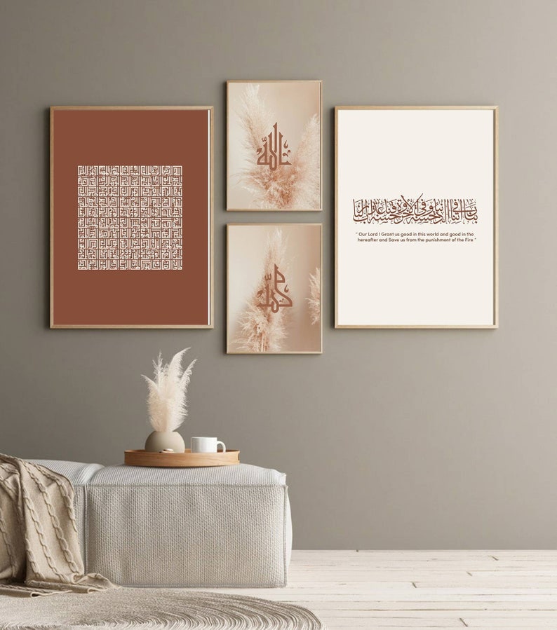 May include: Four framed prints with a brown background and white calligraphy. The prints feature Islamic calligraphy and a quote in Arabic. The prints are arranged in a grid pattern on a light brown wall.