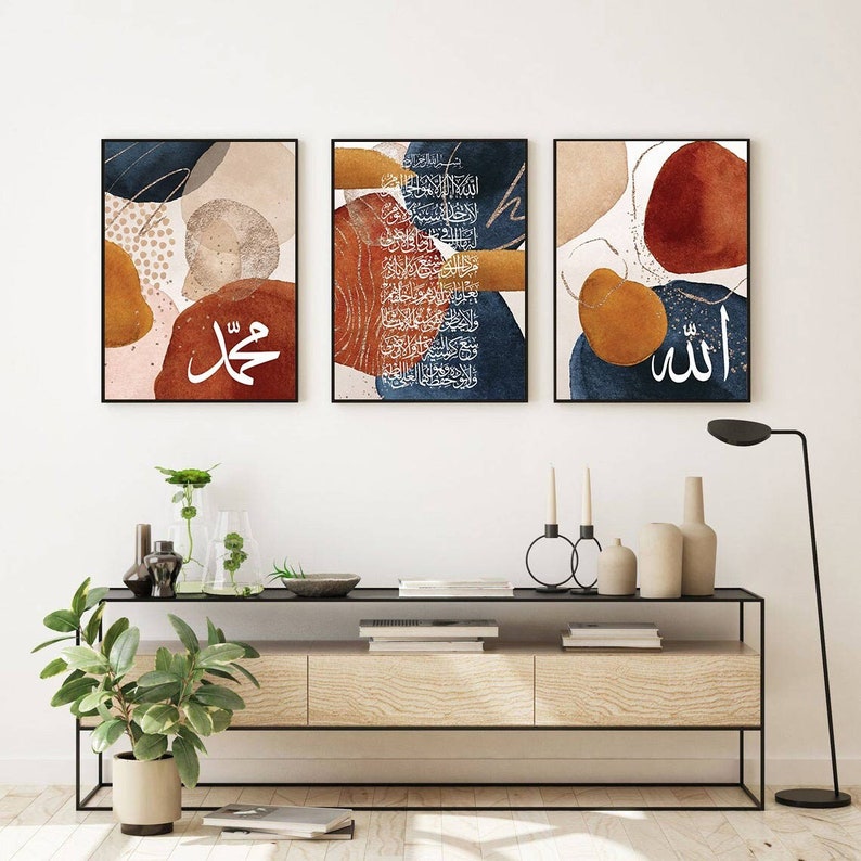 May include: Three abstract art prints with a modern minimalist design. The prints feature a watercolour background with geometric shapes in shades of brown, orange, red, and blue. The prints include Arabic calligraphy in white, reading "Allah", "Muhammad", and a longer passage of text.
