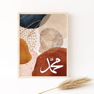 May include: Abstract art print featuring the Arabic calligraphy word "Muhammad" in white on a brown background. The print incorporates a range of shapes and colours, including beige, orange, pink, and blue.