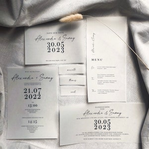 Puede incluir: Un conjunto de invitaciones de boda con un dise&ntilde;o minimalista. La tarjeta de guardar la fecha presenta el texto "Save Our Date" y los nombres "Alexandra & Sammy" con la fecha "30.05.2023". La tarjeta de invitaci&oacute;n de boda presenta el texto "Wir Heiraten" y los nombres "Alexandra + Sammy" con la fecha "21.07.2022". La tarjeta de agradecimiento presenta el texto "Dankesch&ouml;n von Alexandra & Sammy" con la fecha "30.05.2023".