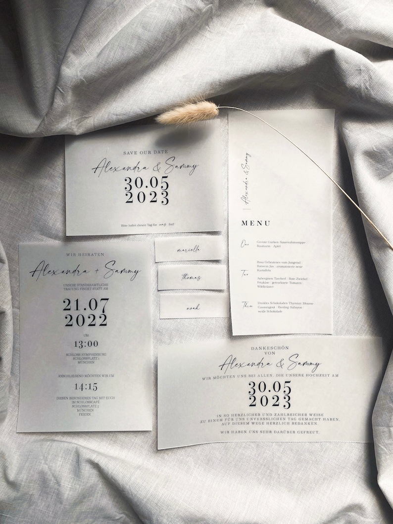 Puede incluir: Un conjunto de invitaciones de boda con un dise&ntilde;o minimalista. La tarjeta de guardar la fecha presenta el texto "Save Our Date" y los nombres "Alexandra & Sammy" con la fecha "30.05.2023". La tarjeta de invitaci&oacute;n de boda presenta el texto "Wir Heiraten" y los nombres "Alexandra + Sammy" con la fecha "21.07.2022". La tarjeta de agradecimiento presenta el texto "Dankesch&ouml;n von Alexandra & Sammy" con la fecha "30.05.2023".