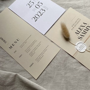 May include: A wedding invitation suite with a cream background and black text. The invitation card features the text "Alexa & Sammy" with a wax seal. The menu card features a list of food items for the wedding reception.