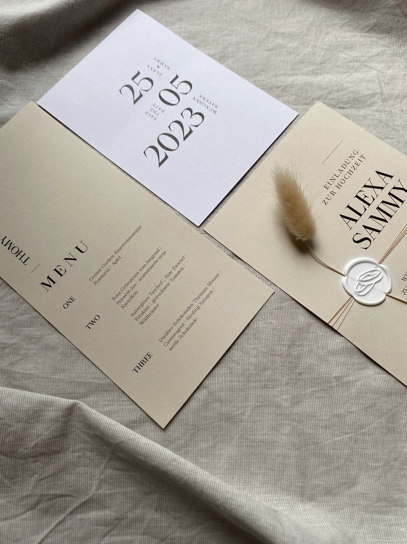 May include: A wedding invitation suite with a cream background and black text. The invitation card features the text "Alexa & Sammy" with a wax seal. The menu card features a list of food items for the wedding reception.