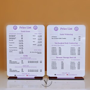 May include: Two white acrylic signs with a price list for tooth gems, teeth whitening, non-surgical body contouring, and vacuum therapy-butt lift. The signs have a pink and purple logo with the text "Kiesmile Beauty".