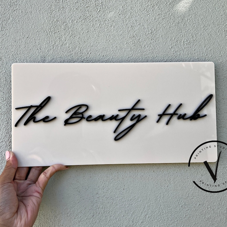 Custom Rectangle acrylic business sign in beige  colour, THE BEAUTY HUB in cursive font displayed on the middle in 3D gloss black acrylic