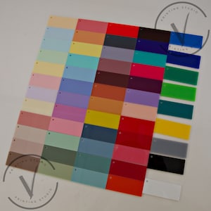 May include: A collection of 48 acrylic sheets in various colors, including light blue, yellow, red, green, and purple. The sheets are arranged in rows and columns, and each sheet has a small hole in the top left corner.