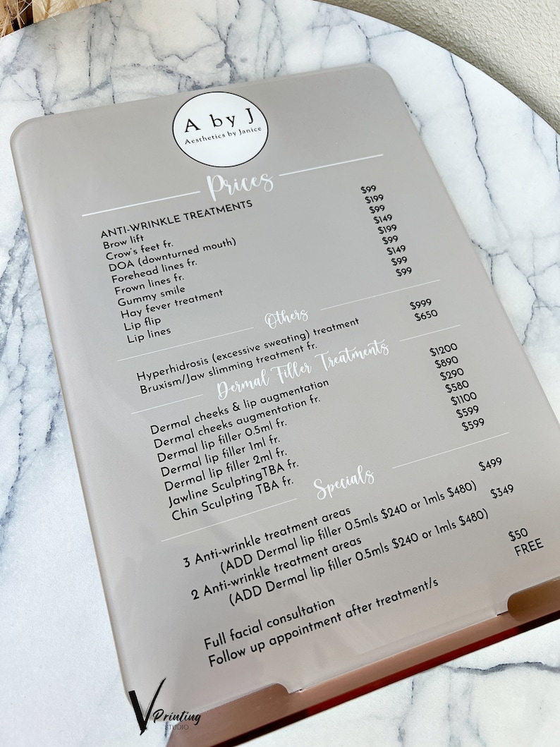 May include: A price list for anti-wrinkle treatments, dermal filler treatments, and specials at a business called "A by J Aesthetics by Janice". The list includes prices for treatments such as brow lift, crow's feet, DOA (downturned mouth), forehead lines, gummy smile, hay fever treatment, lip flip, and lip lines. Dermal filler treatments include dermal cheeks and lip augmentation, dermal cheeks augmentation, dermal lip filler 0.5ml, dermal lip filler 1ml, dermal lip filler 2ml, jawline sculpting, and chin sculpting. Specials include 3 anti-wrinkle treatment areas and 2 anti-wrinkle treatment areas with the option to add dermal lip filler 0.5ml or 1ml. The list also includes prices for a full facial consultation and follow-up appointments.
