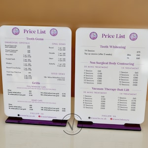 May include: Two white acrylic signs with a purple base, each with a price list for dental services. The left sign lists prices for tooth gems, grills, and full/window caps. The right sign lists prices for teeth whitening, non-surgical body contouring, and vacuum therapy-butt lift.
