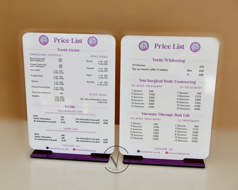 May include: Two white acrylic signs with a purple base, each with a price list for dental services. The left sign lists prices for tooth gems, grills, and full/window caps. The right sign lists prices for teeth whitening, non-surgical body contouring, and vacuum therapy-butt lift.