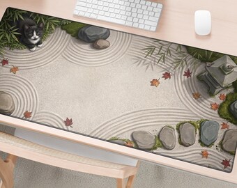 May include: A rectangular desk mat featuring a zen garden illustration with raked sand patterns, scattered autumn leaves, smooth grey stones, green bamboo stalks, a stone lantern, and a black and white cat resting in the upper left corner.