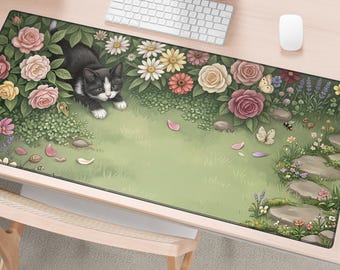 May include: A rectangular desk mat featuring a black and white cat lying in a garden of pink, yellow, and white roses and daisies. The scene includes green grass, scattered flower petals, a stone path, butterflies, and a bee on a light green background.