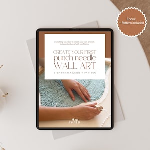 Puede incluir: Una tableta digital que muestra una guía para el arte mural con aguja mágica. La pantalla muestra el texto "Crea tu primer arte mural con aguja mágica" con una guía paso a paso y un patrón. Se incluye un libro electrónico y un patrón. El fondo es un textil azul claro y blanco.