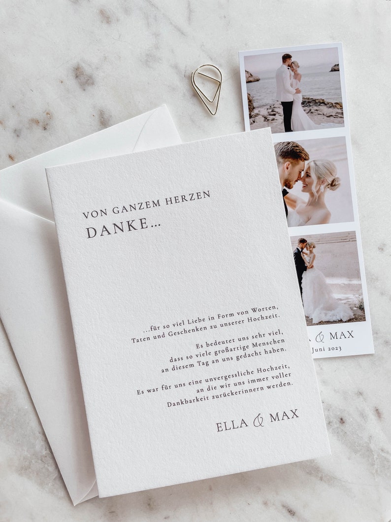 May include: A white thank you card with a simple black font. The card reads "Von Ganzem Herzen Danke..." and includes a message of gratitude for the love and support received at the couple's wedding. The card also includes the couple's names, "Ella & Max", and the date of their wedding, "Juni 2023".