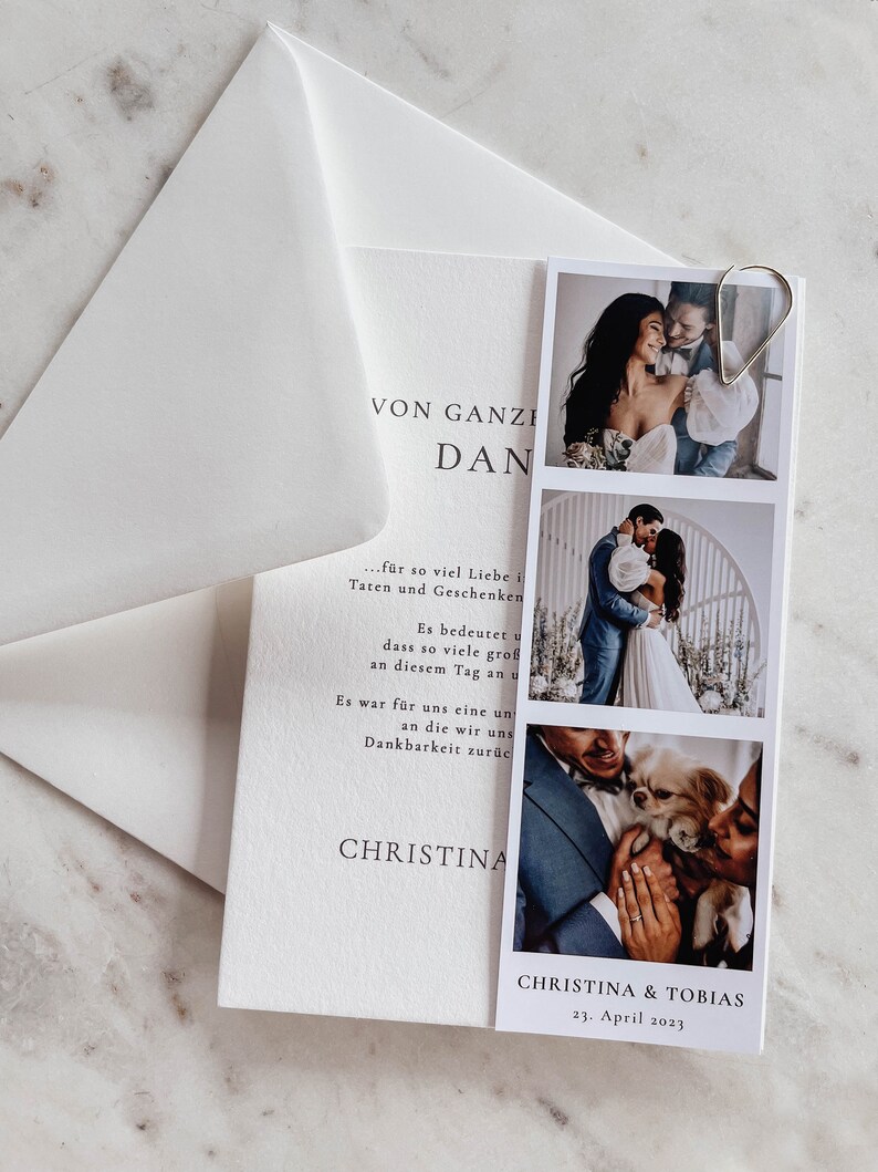May include: A wedding invitation card with a photo collage of the couple and their dog. The card is white with black text that reads "VON GANZEM HERZEN DANKE..." and "CHRISTINA & TOBIAS 23. April 2023".
