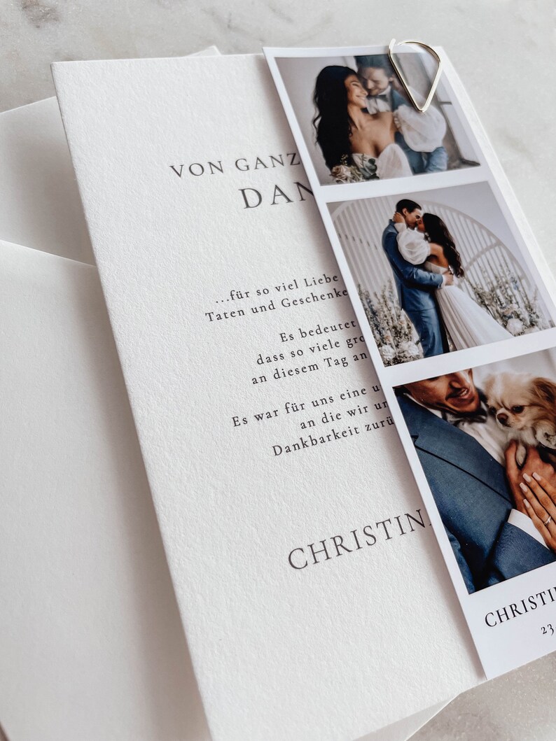 May include: A white card with black text that reads "VON GANZ DAN... f&uuml;r so viel Liebe Taten und Geschenke Es bedeutet dass so viele gro an diesem Tag an Es war f&uuml;r uns eine u an die wir un Dankbarkeit zur&uuml; CHRISTIN CHRISTI 23". The card has three photos attached to it with a silver heart-shaped paper clip.