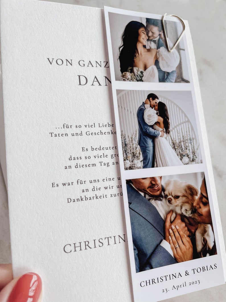 May include: A wedding announcement card with a white background and black text. The text reads "VON GANZ DAN...f&uuml;r so viel Liebe Taten und Geschenke Es bedeutet dass so viele gro&szlig;e Momente an diesem Tag an uns vorbeigezogen sind. Es war f&uuml;r uns eine unvergessliche Zeit, an die wir uns mit gro&szlig;er Dankbarkeit zur&uuml;ck erinnern werden. CHRISTIN" and "CHRISTINA & TOBIAS 23. April 2023". The card features three photos of the couple, including one with their dog.