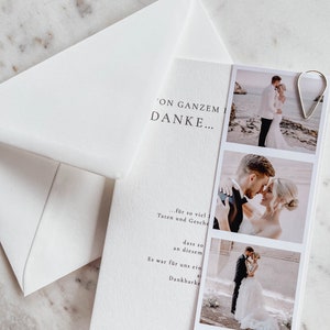May include: A white card with a thank you message for a wedding. The card features three photos of the couple in black and white. The text on the card reads 'On Gazem Danke... for so viel Taten und Gesche dass so an diesem Es war fur uns ein Dankbarke Ella & Max 06. Juni 2023'.