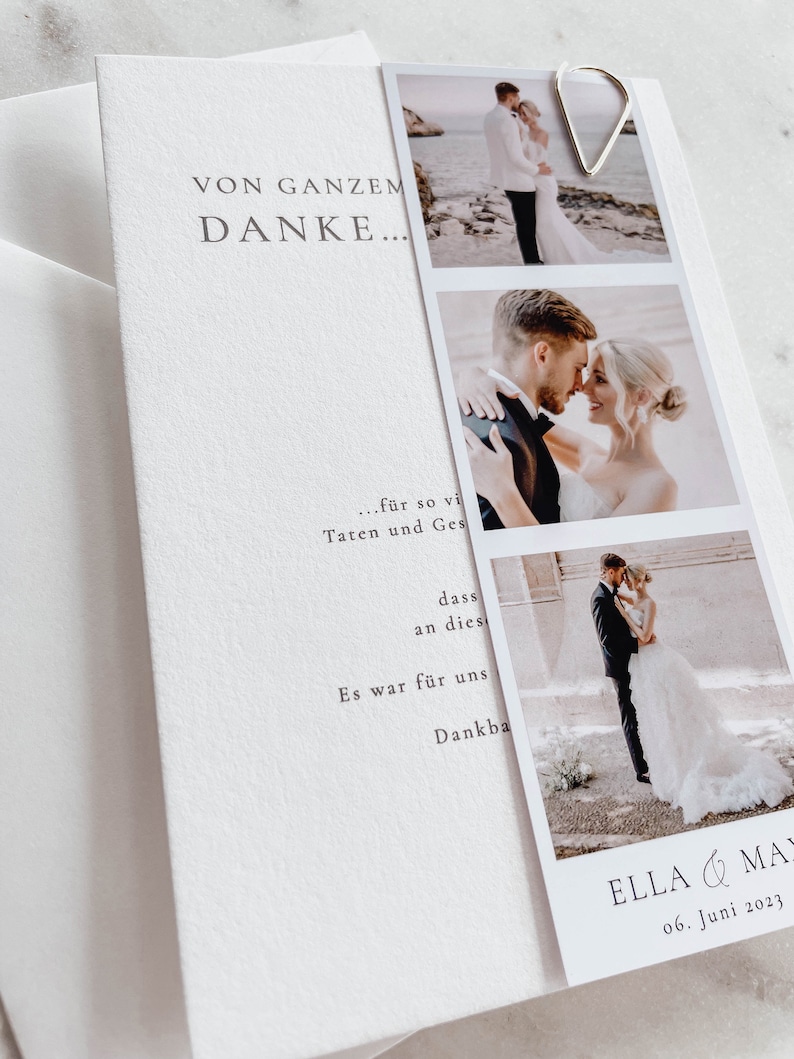May include: A white wedding thank you card with a simple design. The card features a photo strip with three photos of a bride and groom. The text on the card reads "VON GANZEM DANKE... ...f&uuml;r so vi Taten und Ges dass an dies Es war f&uuml;r uns Dankba ELLA & MA 06. Juni 2023"