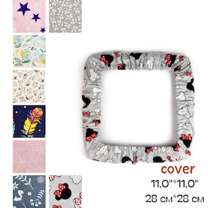 以下が含まれることがあります： 黒と赤のリボンと漫画のキャラクターの頭の模様が入ったグレーのカバー。正方形のカバーのサイズは11.0インチ x 11.0インチ、28 cm x 28 cmです。さまざまなパターンの生地見本もいくつか表示されています。