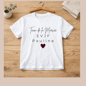 Peut inclure: Une tasse en céramique blanche avec une anse noire et le texte "But First, Coffee" en gras noir. La tasse est posée sur un fond flou, suggérant un cadre chaleureux.