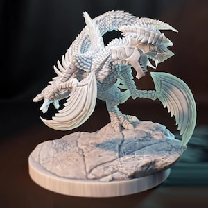 Puede incluir: Figura detallada de un dragón blanco con escamas, alas y garras intrincadas. El dragón está posado sobre una base rocosa, con la boca abierta y las alas extendidas. Escultura coleccionable de temática fantástica.