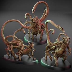 Puede incluir: Tres figuras detalladas de criaturas fantásticas de color beige. Cada figura tiene un torso humanoide, cuatro patas y una larga cola curvada con una cabeza de serpiente. Las criaturas están posadas sobre bases circulares negras, con un fondo oscuro.