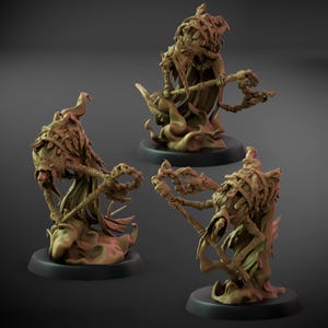 Puede incluir: Tres miniaturas de fantasía detalladas, de color beige, de una figura con capa y un bastón, sobre bases circulares negras. Las figuras tienen una apariencia esquelética, con detalles de hojas y elementos etéreos fluidos.