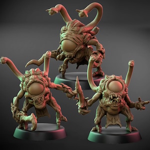 Puede incluir: Tres miniaturas de criaturas fantásticas marrones con grandes ojos centrales, múltiples tentáculos y dientes afilados. Cada figura se encuentra sobre una base negra, una de ellas sosteniendo una cuchilla. Las figuras son detalladas y texturizadas.