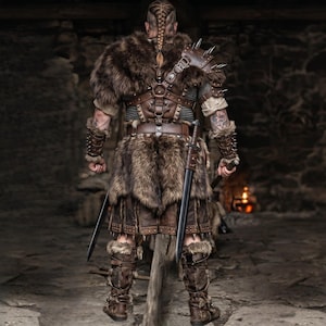 May include: A warrior's ensemble featuring a fur cloak, leather armor, and a skirt. The outfit includes spiked shoulder pads, wrist cuffs, and boots. Two swords are held at the sides. The color palette is dominated by browns and tans, with a focus on texture.