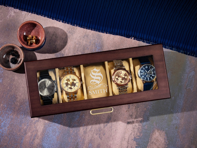 May include: A wooden watch box with a glass top, displaying four watches. The box has a personalized inscription that reads "S SMITH".