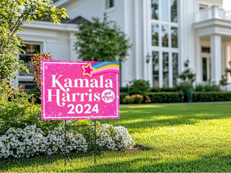 May include: Pink and white yard sign with glitter and a rainbow design. The sign reads "Kamala Harris and Tim! 2024".