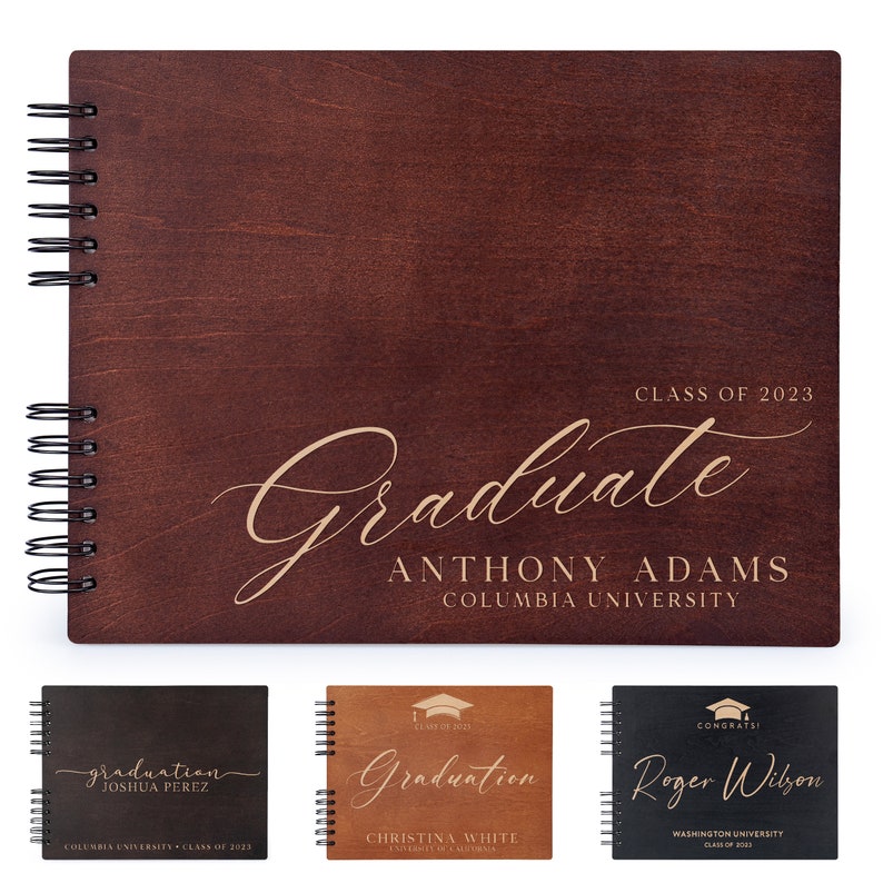May include: A brown wooden photo album with a gold inscription that reads "Class of 2023 Graduate Anthony Adams Columbia University". The album has a spiral binding and is closed.