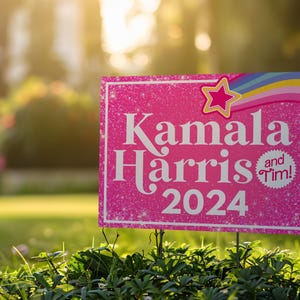 May include: Pink yard sign with glitter and a rainbow design. The sign reads "Kamala Harris and Tim! 2024".