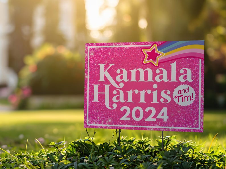 May include: Pink yard sign with glitter and a rainbow design. The sign reads "Kamala Harris and Tim! 2024".