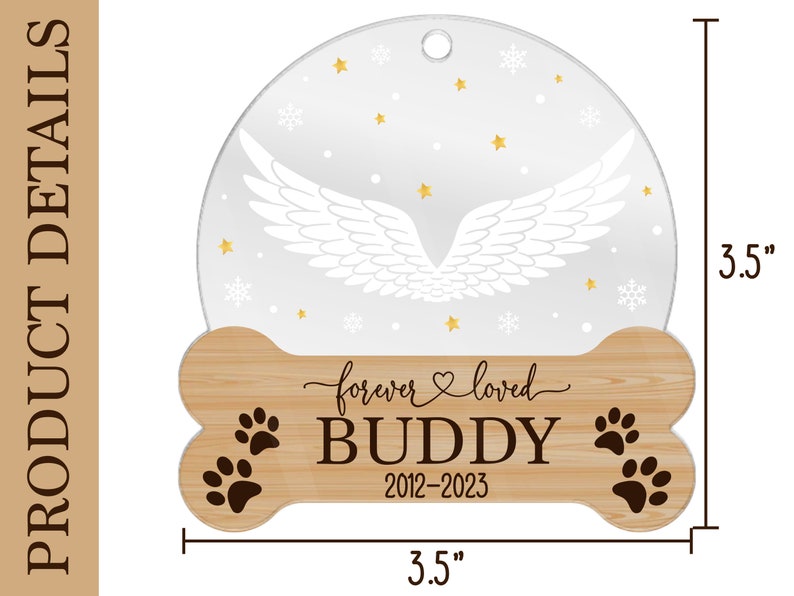 May include: A circular ornament with a bone-shaped wooden base measuring 3.5 inches by 3.5 inches. The top features white angel wings, gold stars, and snowflakes. The base displays the text "forever loved", "BUDDY", and "2012-2023" with paw prints.