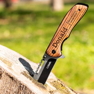 May include: A personalized pocket knife with a wooden handle. The handle is engraved with the name "Donald" and the text "Groomsman 07.08.2023".