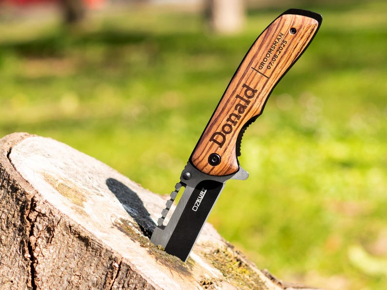 May include: A personalized pocket knife with a wooden handle. The handle is engraved with the name "Donald" and the text "Groomsman 07.08.2023".