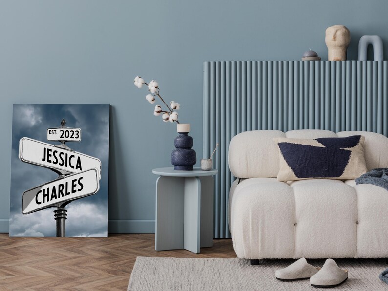 Op de afbeelding: Een canvas print met een straatnaambord met de namen "Jessica" en "Charles" en de tekst "Est. 2023". Het bord is tegen een bewolkte lucht.