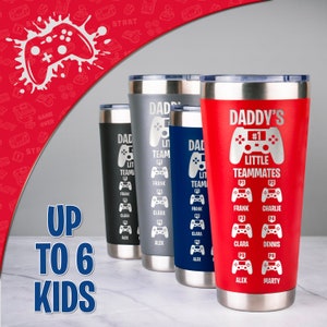 May include: Four stainless steel tumblers with a gamer theme. The tumblers are red, gray, blue, and black. Each tumbler has a design of a video game controller with the text "Daddy's #1 Little Teammates" and the names of up to six children.