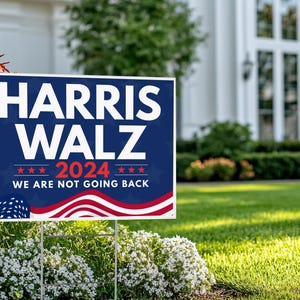 May include: A blue and red political yard sign with the text "HARRIS WALZ 2024 WE ARE NOT GOING BACK" and a stylized American flag design.